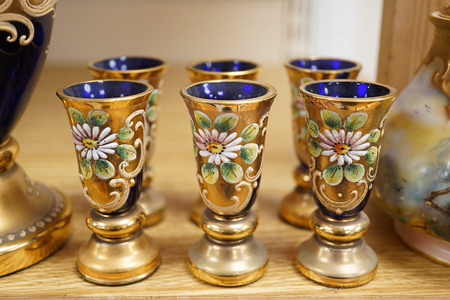 A Royal Worcester peacock painted jar and cover and a Bohemian blue glass decanter and six glasses, with gilt and enamel decoration, decanter 26cm high including stopper. Condition - finial to Worcester pot cover chipped